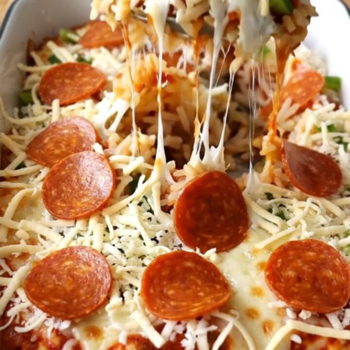 A top-down view of a rectangular baking dish filled with a pepperoni pizza stuffed pepper casserole.