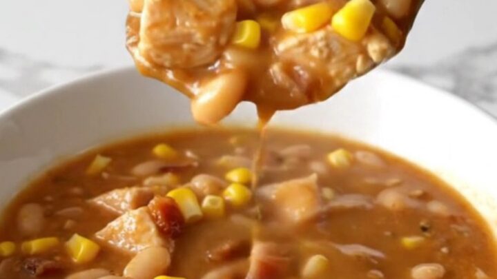 A bowl of creamy crack chicken chili topped with bacon bits and corn, showing a thick and savory texture.
