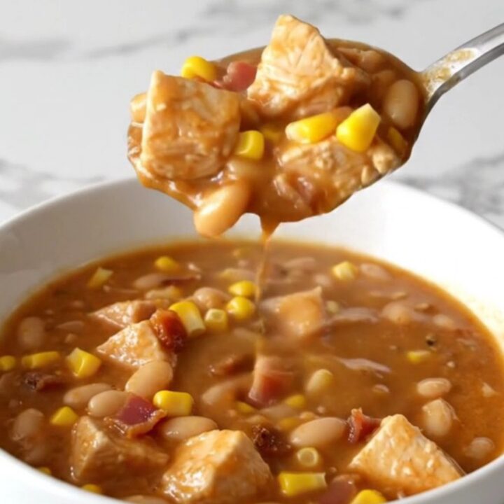 A bowl of creamy crack chicken chili topped with bacon bits and corn, showing a thick and savory texture.