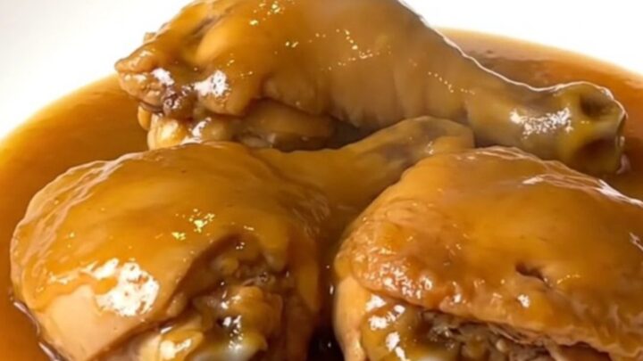 Tender boneless skinless chicken thighs coated in a glossy amber duck sauce in a slow cooker.