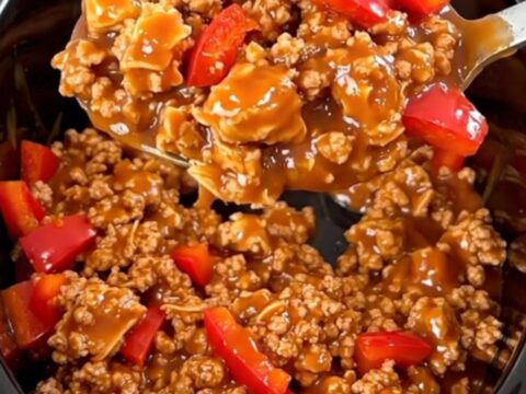 A close-up of slow-cooked ground turkey with red bell peppers in a glossy, spicy red sauce served in a bowl.