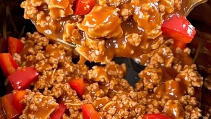 A close-up of slow-cooked ground turkey with red bell peppers in a glossy, spicy red sauce served in a bowl.