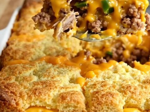 A golden, bubbly green chile turkey and cornbread bake in a white ceramic dish.