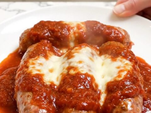 Slow cooker filled with cooked Italian sausages, melted mozzarella, Parmesan, and rich marinara sauce.
