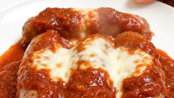 Slow cooker filled with cooked Italian sausages, melted mozzarella, Parmesan, and rich marinara sauce.