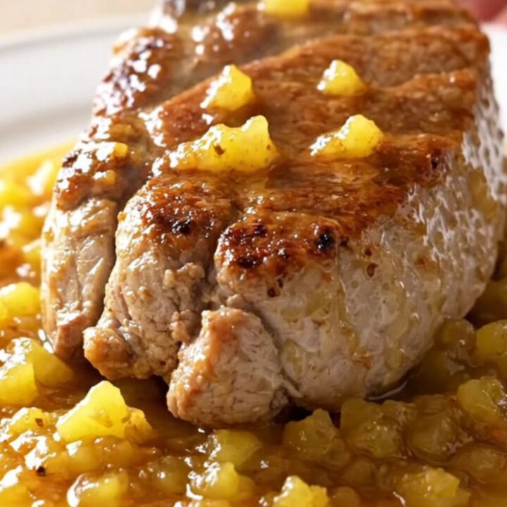 A slow cooker filled with pork tenderloin, pineapple chunks, and a rich, spiced jerk sauce.