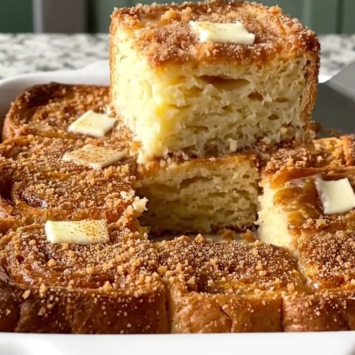 A golden, puffed French toast bake fresh from the oven in a rectangular ceramic dish.