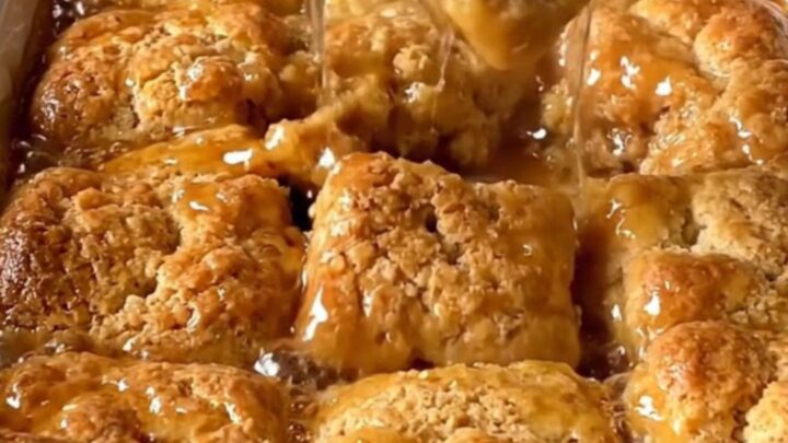 A top-down view of a rectangular ceramic dish filled with golden baked cinnamon honey butter biscuits.