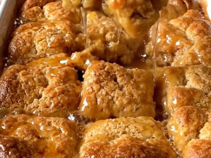 A top-down view of a rectangular ceramic dish filled with golden baked cinnamon honey butter biscuits.
