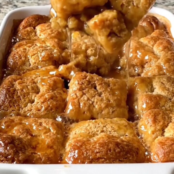 A top-down view of a rectangular ceramic dish filled with golden baked cinnamon honey butter biscuits.