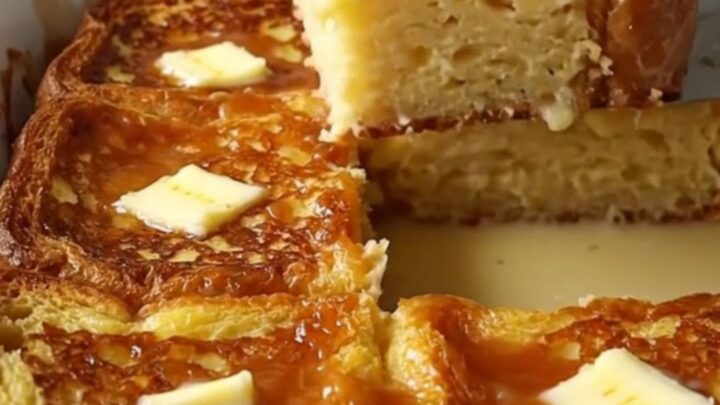 A rectangular ceramic dish filled with golden-brown, custard-soaked French toast slices with a caramelized sugar crust.