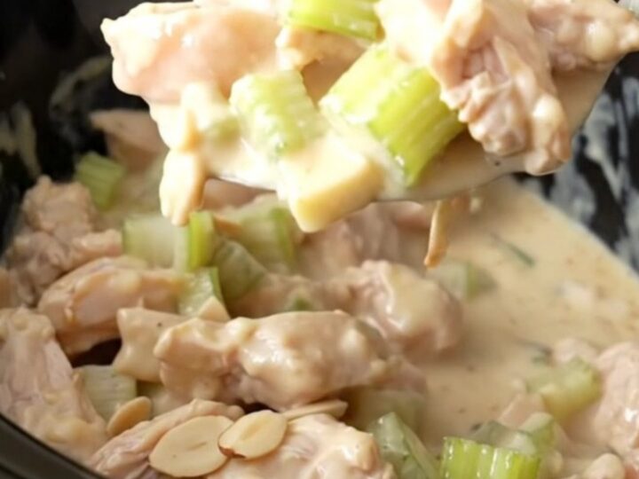 Creamy almond chicken with visible chicken pieces and slivered almonds in a white bowl.