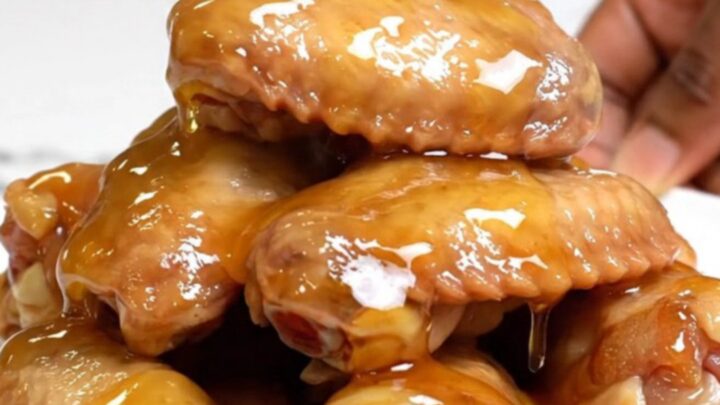 A platter of slow-cooked chicken wings glazed with hot honey and seasoned with lemon pepper.