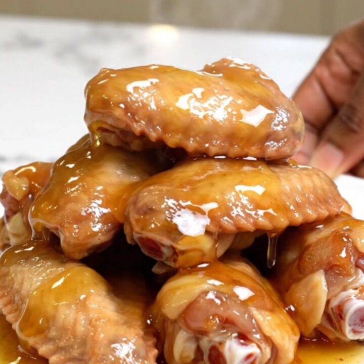 A platter of slow-cooked chicken wings glazed with hot honey and seasoned with lemon pepper.