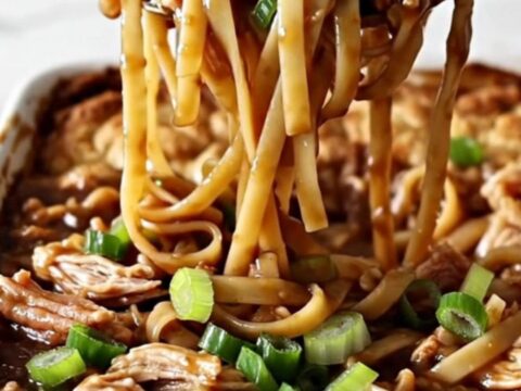 A large white rectangular baking dish filled with cooked linguine and ground turkey in a dark, glossy sauce.