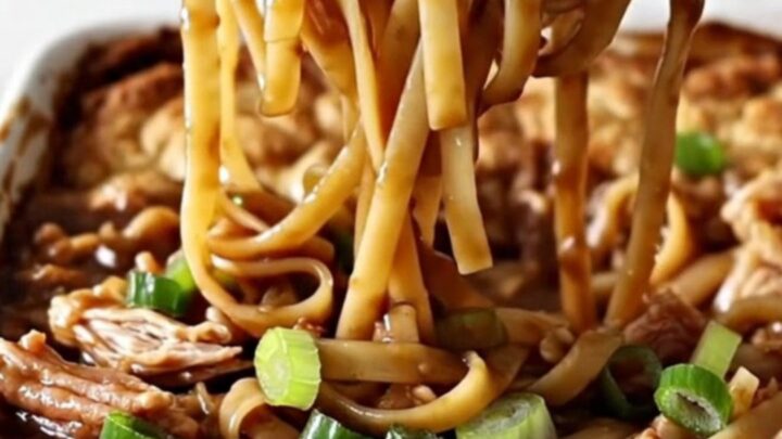 A large white rectangular baking dish filled with cooked linguine and ground turkey in a dark, glossy sauce.