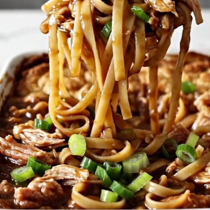 A large white rectangular baking dish filled with cooked linguine and ground turkey in a dark, glossy sauce.