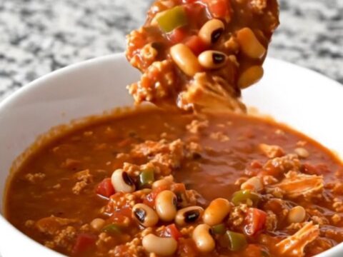 A warm, hearty bowl of black-eyed pea and turkey chili with visible crumbles of meat and whole peas.