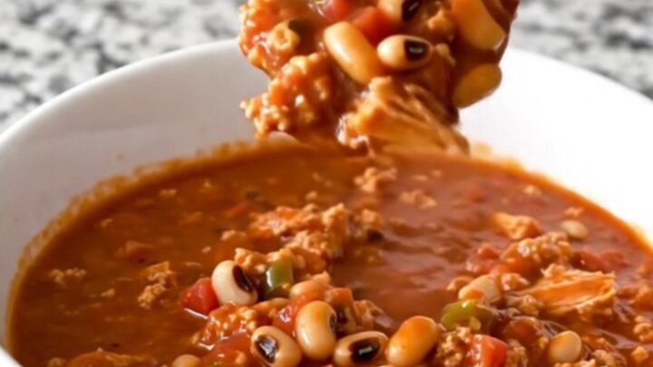 A warm, hearty bowl of black-eyed pea and turkey chili with visible crumbles of meat and whole peas.