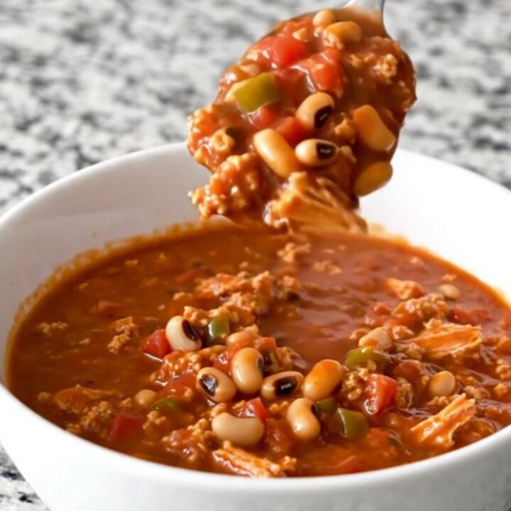 A warm, hearty bowl of black-eyed pea and turkey chili with visible crumbles of meat and whole peas.