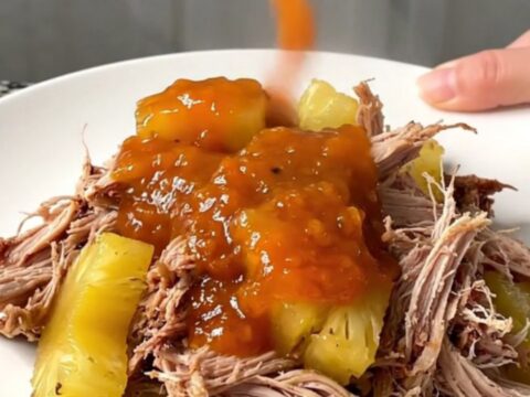 A close-up of pineapple habanero pulled pork sliders on a platter with steam rising.