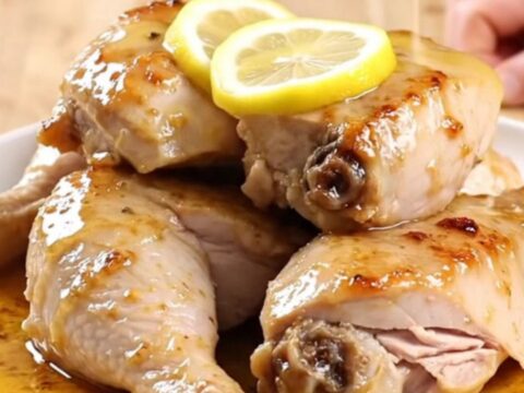 A plate of tender, slow-cooked lemon pepper turkey breast garnished with soft lemon slices.