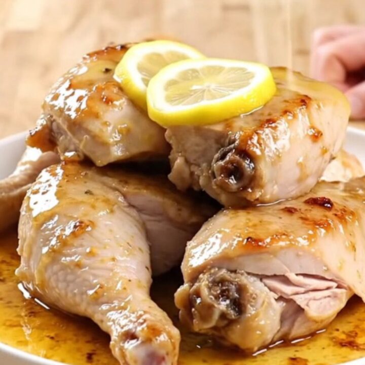 A plate of tender, slow-cooked lemon pepper turkey breast garnished with soft lemon slices.