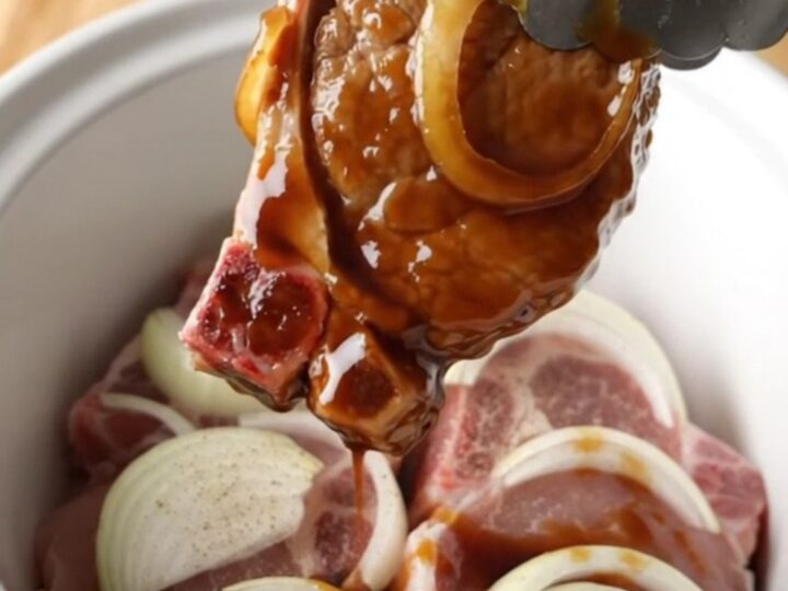 Tender slow-cooked pork chops glazed in a rich, dark sweet soy sauce with soft onion slices.