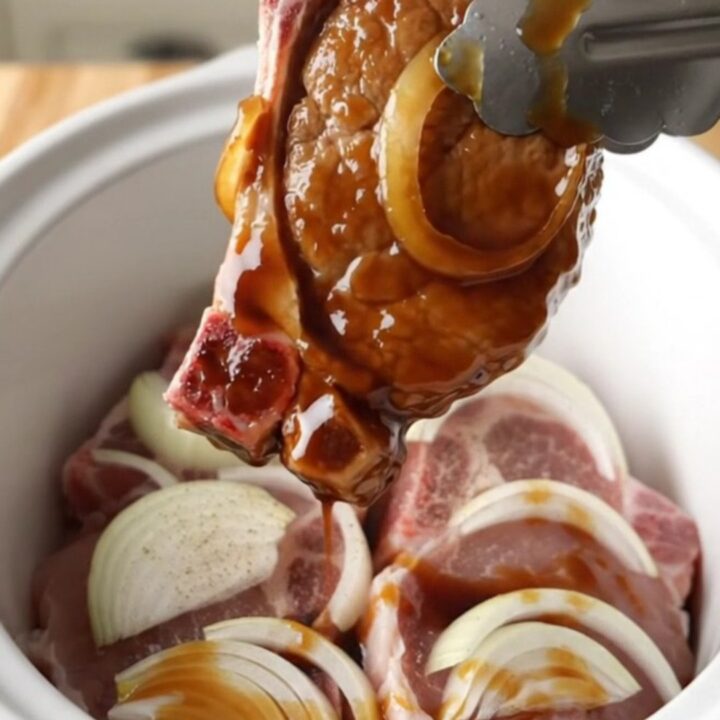 Tender slow-cooked pork chops glazed in a rich, dark sweet soy sauce with soft onion slices.