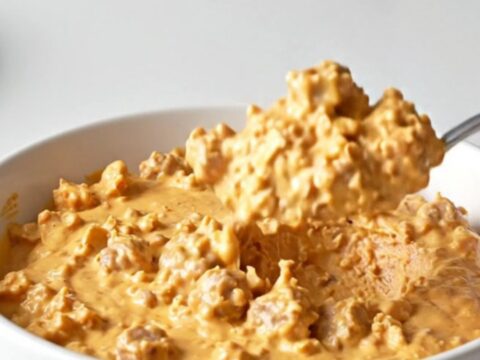 A close-up shot of the creamy Crockpot Hanky Panky Dip in a slow cooker, featuring browned meat and melted cheese.