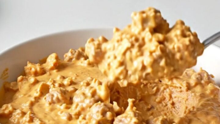 A close-up shot of the creamy Crockpot Hanky Panky Dip in a slow cooker, featuring browned meat and melted cheese.