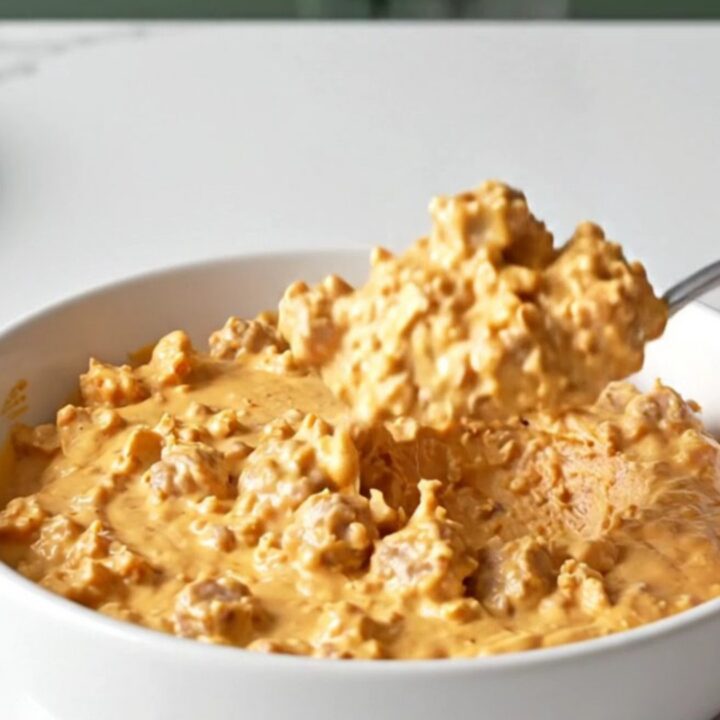 A close-up shot of the creamy Crockpot Hanky Panky Dip in a slow cooker, featuring browned meat and melted cheese.