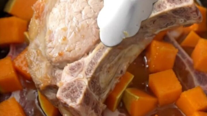 A close-up of tender bone-in pork chops and cubes of butternut squash coated in a glossy brown sugar glaze.