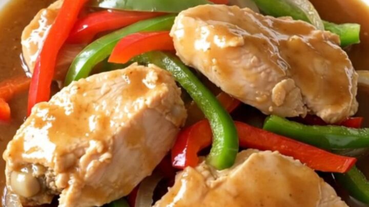 A close-up of slow cooker chicken pepper steak served on a white plate with visible steam.