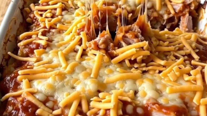 A large rectangular ceramic dish filled with a baked turkey and pasta sloppy joe casserole topped with melted cheddar cheese.
