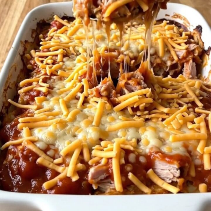 A large rectangular ceramic dish filled with a baked turkey and pasta sloppy joe casserole topped with melted cheddar cheese.