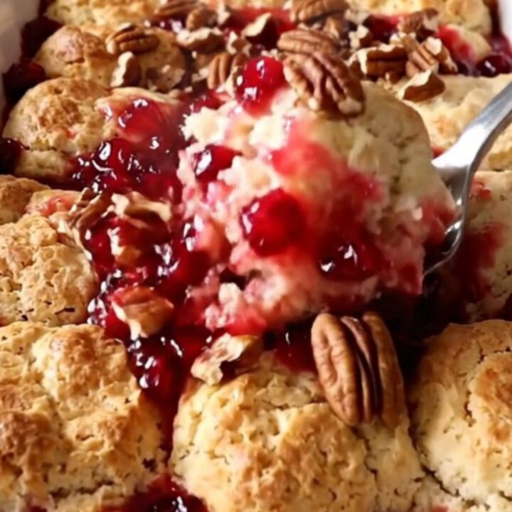 A warm, golden cranberry pecan biscuit bake in a white ceramic dish.