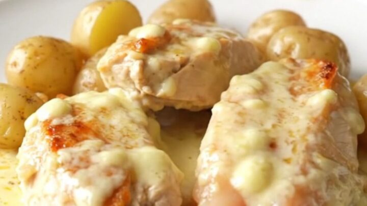 A high-angle shot showing tender chicken breasts and halved baby potatoes covered in a rich