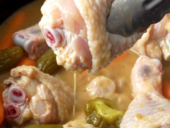 Slow cooker Mississippi chicken drumsticks with bright orange baby carrots and green pepperoncini in a savory buttery gravy.
