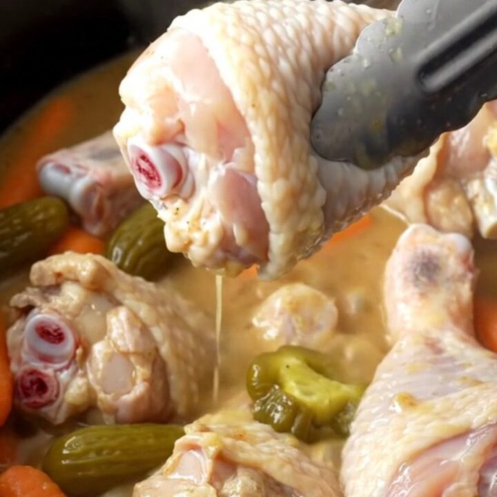 Slow cooker Mississippi chicken drumsticks with bright orange baby carrots and green pepperoncini in a savory buttery gravy.