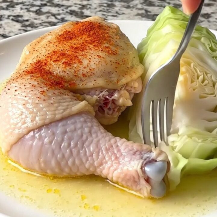Slow cooker chicken thighs with smoky paprika and cabbage in a black stoneware insert.