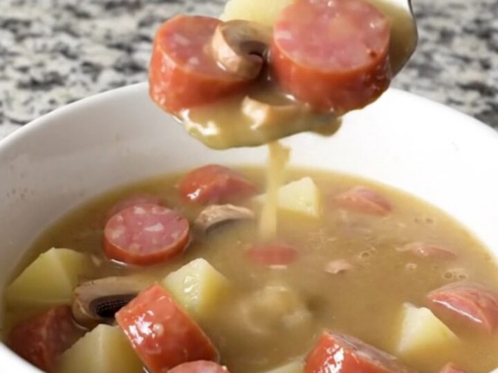 A bowl of creamy kielbasa stroganoff soup featuring sliced sausage, mushrooms, and gold potatoes in a rich, creamy broth.