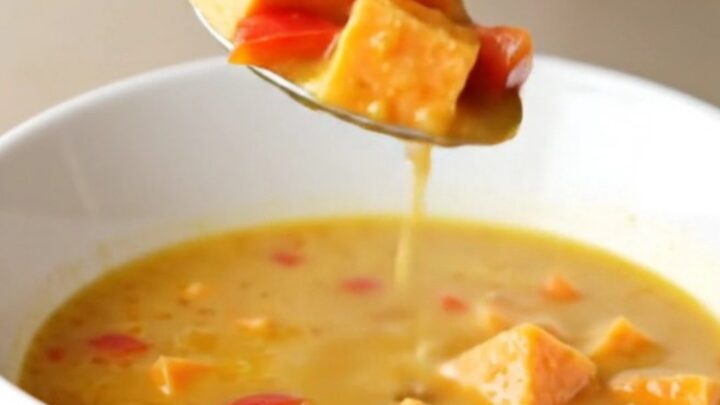 Creamy coconut curry sweet potato soup in a bowl with visible chunks of potato and red pepper.