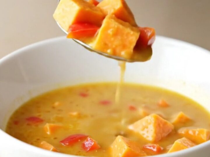 Creamy coconut curry sweet potato soup in a bowl with visible chunks of potato and red pepper.