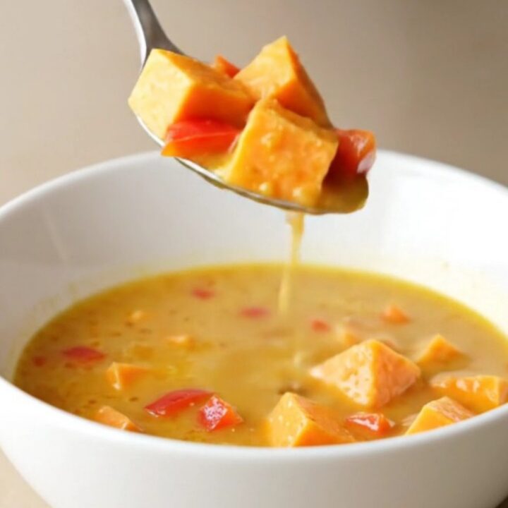 Creamy coconut curry sweet potato soup in a bowl with visible chunks of potato and red pepper.