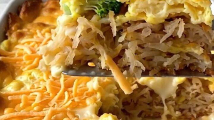 A golden, bubbling broccoli cheddar hash brown egg bake in a white ceramic dish on a quartz countertop.