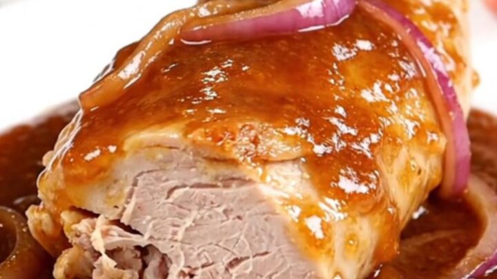 Slow cooked honey chipotle turkey tenderloin served on a white plate with red onions.