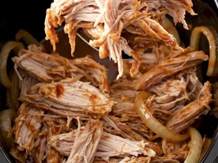 A close-up of shredded smoky chipotle turkey sliders on soft buns, garnished with fresh herbs.