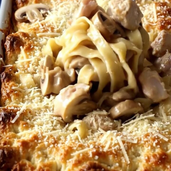 A top-down view of a rectangular baker filled with creamy Chicken Marsala and egg noodles.