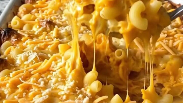 A top-down view of a creamy butternut squash mac and cheese bake in a ceramic dish, covered in golden melted sharp cheddar.
